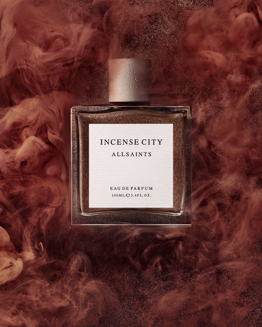 Product shot of the Incense City perfume bottle on a smokey red background.