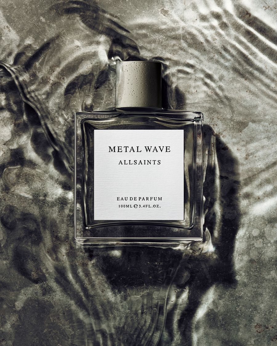 Product shot of the Metal Wave perfume bottle on a a liquid grey background.